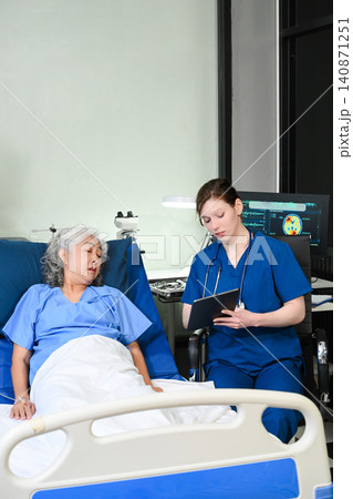 A professional nurse provides care and support to an elderly Asian woman in a hospital bed, representing geriatric healthcare, patient comfort, and medical wellness services. A professional nurse provides care and support to an elderly Asian woman in a hospital bed, representing geriatric healthcare, patient comfort, and medical wellness services. 140871251