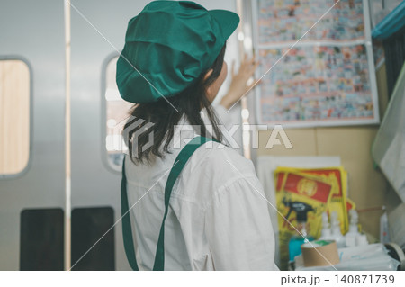 スーパーマーケットのバックヤードで壁のチラシに手を当てて確認する女性スタッフの後ろ姿 140871739