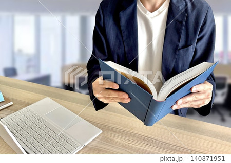 オフィスで本や資料を読むビジネスマン オフィスで本や資料を読むビジネスマン 140871951