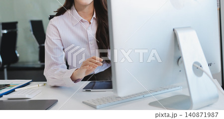 Young businesswoman professional employee using pc doing online banking analysing at workplace. Asian middle-aged business woman working on laptop computer in office, taking notes. Banner, copy space Young businesswoman professional employee using pc doing online banking analysing at workplace. Asian middle-aged business woman working on laptop computer in office, taking notes. Banner, copy space 140871987