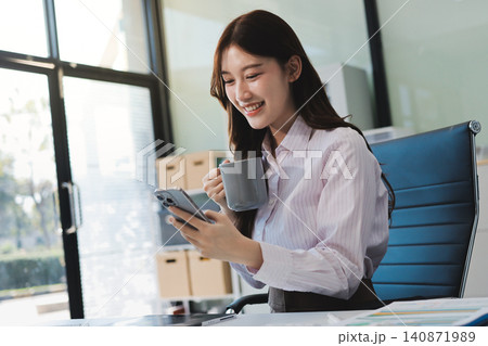 Young businesswoman professional employee using pc doing online banking analysing at workplace. Asian middle-aged business woman working on laptop computer in office, taking notes. Banner, copy space Young businesswoman professional employee using pc doing online banking analysing at workplace. Asian middle-aged business woman working on laptop computer in office, taking notes. Banner, copy space 140871989
