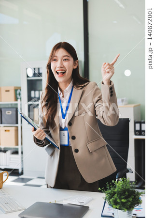 Young businesswoman professional employee using pc doing online banking analysing at workplace. Asian middle-aged business woman working on laptop computer in office, taking notes. Banner, copy space Young businesswoman professional employee using pc doing online banking analysing at workplace. Asian middle-aged business woman working on laptop computer in office, taking notes. Banner, copy space 140872001