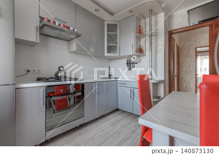 Contemporary Apartment Kitchen Interior with Grey Cabinets and Red Chairs Contemporary Apartment Kitchen Interior with Grey Cabinets and Red Chairs 140873130