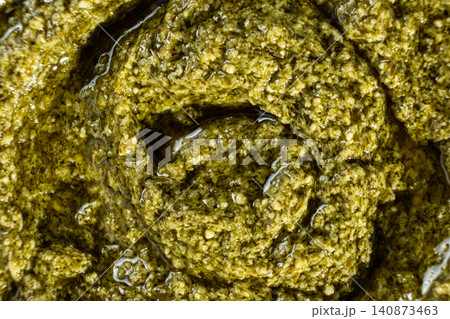 Close-up texture of fresh green pesto sauce with olive oil Close-up texture of fresh green pesto sauce with olive oil 140873463