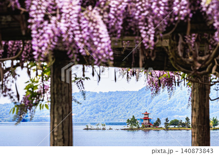 美しく咲き誇る紫色の藤の花越しに望む穏やかな洞爺湖と湖畔に佇む浮見堂の風情ある景色 美しく咲き誇る紫色の藤の花越しに望む穏やかな洞爺湖と湖畔に佇む浮見堂の風情ある景色 140873843