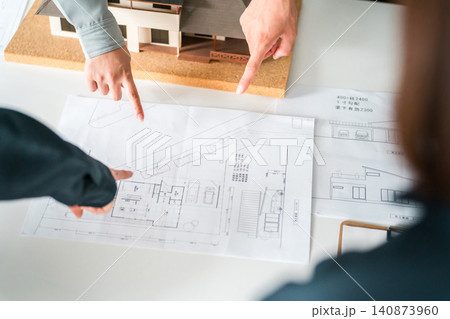 住宅模型,設計図を指差すビジネスマンの手元 住宅模型,設計図を指差すビジネスマンの手元 140873960