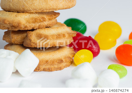 Danish butter cookies, colorful candies, and marshmallows on a white background. Close-up. Danish butter cookies, colorful candies, and marshmallows on a white background. Close-up. 140874274