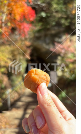 秋の紅葉ハイキングで梅干しを持つ手 塩分補給・熱中症対策イメージ 140874729