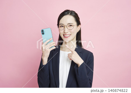 スマホを指差す笑顔のビジネスウーマン スマホを指差す笑顔のビジネスウーマン 140874822