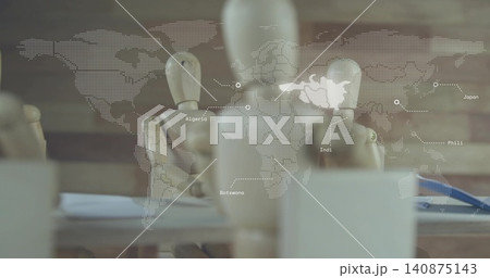 Displaying central wooden mannequin and other mannequins on studio table, with world map overlay 140875143