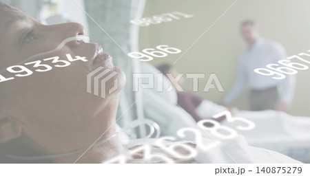 Receiving oxygen via nasal cannula, male patient lying on hospital bed wearing gown, data overlays 140875279