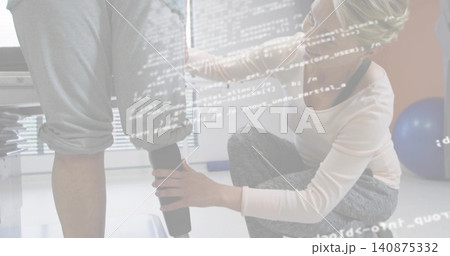 Adjusting kneeling therapist fitting prosthetic leg on patient in clinic, wearing gray leggings Adjusting kneeling therapist fitting prosthetic leg on patient in clinic, wearing gray leggings 140875332