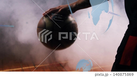Resting basketball player holding ball on wooden court, in dark red-panel kit, blue fog overlays 140875869