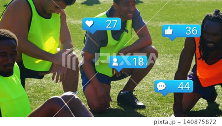 Gathering four soccer players wearing neon pinnies and cleats, resting on grass with blue badges Gathering four soccer players wearing neon pinnies and cleats, resting on grass with blue badges 140875872