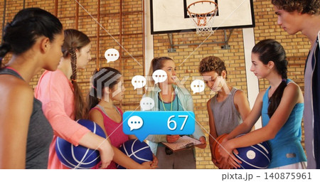 Coaching coach in jacket holding clipboard, whistle, guiding youth in school gym with blue balls 140875961