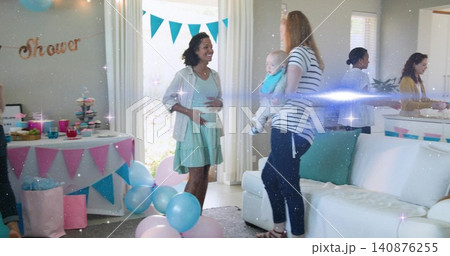 Smiling pregnant woman cradling belly in living room, wearing mint dress and cardigan with balloons Smiling pregnant woman cradling belly in living room, wearing mint dress and cardigan with balloons 140876255