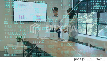 Reviewing deck, business-casual team pointing at laptop and screen in meeting room, binary overlay 140876256