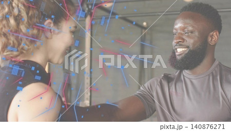 Greeting female in black top and bearded man in gray shirt fist-bumping at gym, tech overlay Greeting female in black top and bearded man in gray shirt fist-bumping at gym, tech overlay 140876271