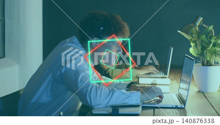 Typing worker wearing light shirt and headphones at long wooden table with neon overlays Typing worker wearing light shirt and headphones at long wooden table with neon overlays 140876338