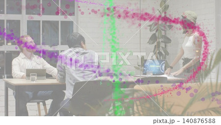 Presenting beanie-clad woman handling papers at office table with laptops and colorful overlay Presenting beanie-clad woman handling papers at office table with laptops and colorful overlay 140876588