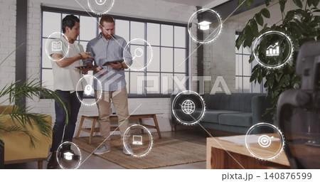 Reviewing tablets, colleagues in white blouse and blue shirt studying HUD icons in loft, copy space Reviewing tablets, colleagues in white blouse and blue shirt studying HUD icons in loft, copy space 140876599