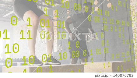 Stepping female in black shorts, male in grey t-shirt performing plyo boxes in gym, with rings Stepping female in black shorts, male in grey t-shirt performing plyo boxes in gym, with rings 140876792