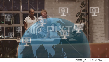 Collaborating team leaning over woman in white sleeveless top using tablet in office with globe Collaborating team leaning over woman in white sleeveless top using tablet in office with globe 140876799