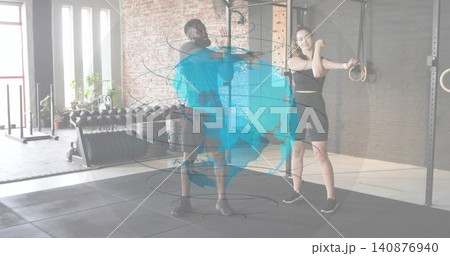 Stretching two adults wearing athletic gear in gym, with dumbbell rack and holographic globe 140876940