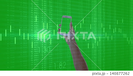 Holding raised bare forearm and hand showing phone on green data backdrop with charts and tickers Holding raised bare forearm and hand showing phone on green data backdrop with charts and tickers 140877262