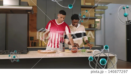 Making two men red-shirt beige-pullover assembling dough on board at kitchen island, with sauce Making two men red-shirt beige-pullover assembling dough on board at kitchen island, with sauce 140877297