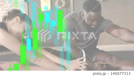 Stretching two training partners in athletic wear reaching feet in gym on mats, candlestick overlay 140877313