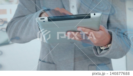 Holding tablet, professional in gray blazer in office, showing wristwatch with blue glass overlays Holding tablet, professional in gray blazer in office, showing wristwatch with blue glass overlays 140877688