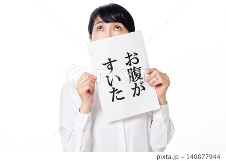 お腹がすいたと書かれた紙を持ち上を見る白いシャツを着た中年女性 お腹がすいたと書かれた紙を持ち上を見る白いシャツを着た中年女性 140877944