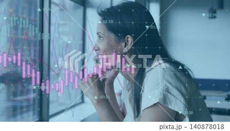 Leaning woman in light blouse gazing at glass pane, desk with market charts overlaid, copy space 140878018