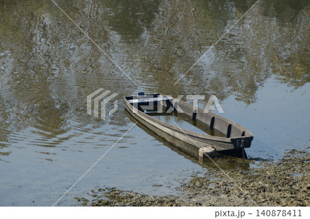 Small wooden boat on calm water Small wooden boat on calm water 140878411