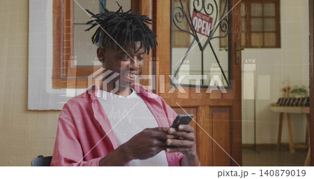 Sitting man in pink shirt over white tee, holding smartphone, scrolling at entrance with OPEN sign Sitting man in pink shirt over white tee, holding smartphone, scrolling at entrance with OPEN sign 140879019