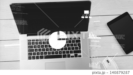 Showing laptop with keys, trackpad, running code on screen at wood desk, tablet, mouse, charts Showing laptop with keys, trackpad, running code on screen at wood desk, tablet, mouse, charts 140879287