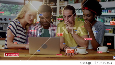 Leaning group of four people gathering around silver laptop at cafe counter with social stickers 140879303