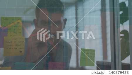 Drawing man in gray shirt annotating glass panel at office, holding marker, sticky notes, red arrow Drawing man in gray shirt annotating glass panel at office, holding marker, sticky notes, red arrow 140879428