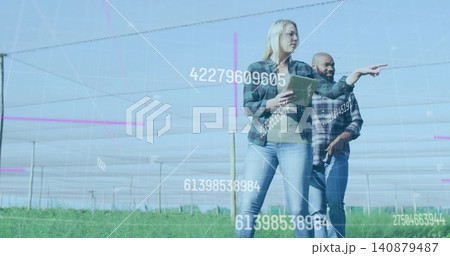 Pointing manager in flannel with tablet, guiding farmer in plaid in netted rows with overlays 140879487