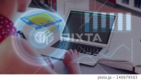 Typing teenage girl wearing red polka-dot top using silver laptop at desk, HUD overlays, copy space 140879583