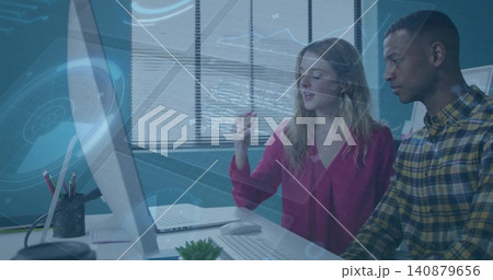 Discussing two colleagues reviewing hologram on monitor at office in red blouse and yellow plaid Discussing two colleagues reviewing hologram on monitor at office in red blouse and yellow plaid 140879656
