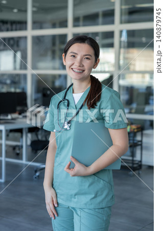 Young asian female doctor feeling positive and smiling nicely Young asian female doctor feeling positive and smiling nicely 140879745
