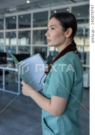 Young female doctor holding medical history of the patient Young female doctor holding medical history of the patient 140879747