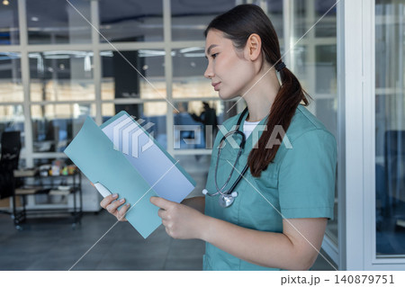 Young female doctor holding medical history of the patient Young female doctor holding medical history of the patient 140879751