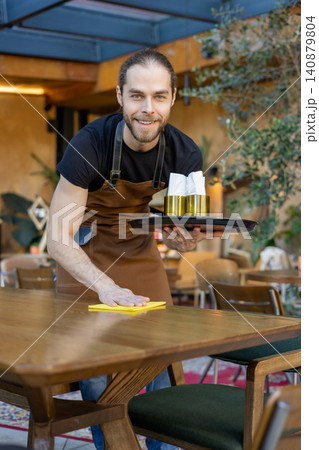 Friendly server cleaning table with yellow cloth Friendly server cleaning table with yellow cloth 140879804