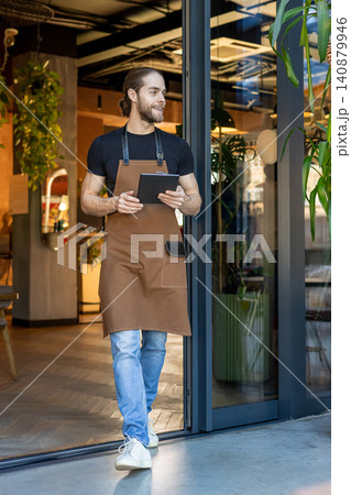 Happy barista looking away holding tablet 140879946