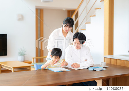 勉強する小学一年生の男の子と教える両親 勉強する小学一年生の男の子と教える両親 140880254
