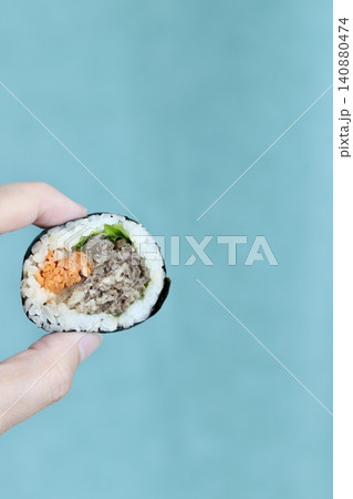 左手で持ち上げた韓国海苔巻きプルコギキンパ 左手で持ち上げた韓国海苔巻きプルコギキンパ 140880474