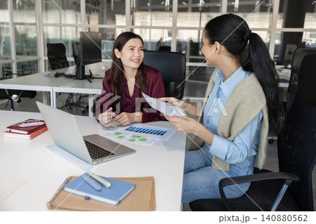 Cheerful coworkers discussing financial report Cheerful coworkers discussing financial report 140880562
